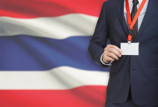 Geschäftsmann, ein Schlüsselband mit einer Nationalflagge auf Hintergrund - Thailand Karte Namensschild festhalten — Stockfoto