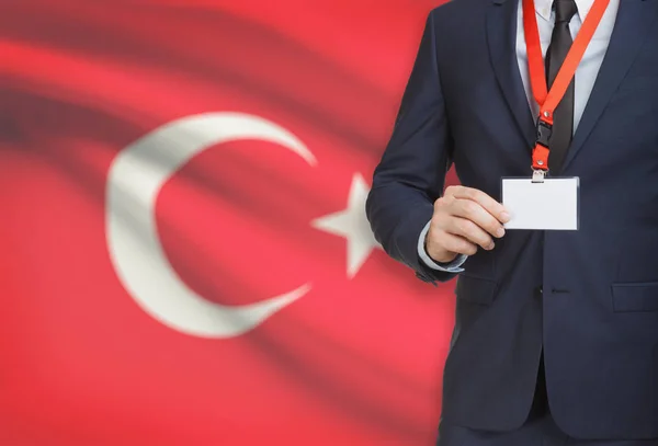 Businessman holding name card badge on a lanyard with a national flag on background - Turkey — Stock Photo, Image