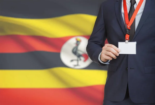 背景 - ウガンダの国旗ストラップの名前カード バッジを保持している実業家 — ストック写真
