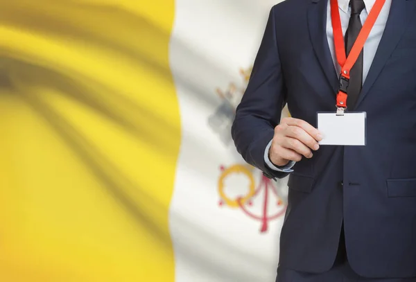 Επιχειρηματίας που κατέχουν κάρτα διακριτικό όνομα σε ένα κορδόνι με μια εθνική σημαία σε φόντο - πόλη του Βατικανού — Φωτογραφία Αρχείου
