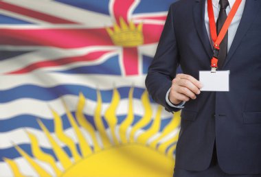 Arka plan - British Columbia Kanada eyaleti bayrağı ile bir ip üzerinde işadamı holding rozet