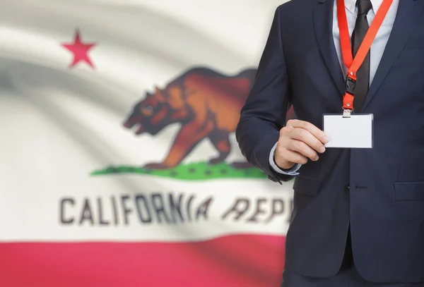 Distintivo di holding dell'uomo d'affari su un cordino con bandiera Usa su priorità bassa - California — Foto Stock