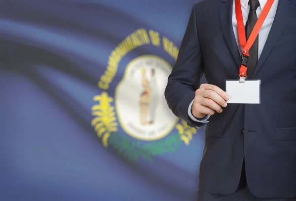 Empresario celebración tarjeta de identificación en un elemento de amarre con bandera de estado de Estados Unidos en el fondo - Kentucky —  Fotos de Stock