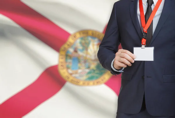 Geschäftsmann Holding Abzeichen auf ein Schlüsselband mit Usa Flagge auf Hintergrund - Florida — Stockfoto