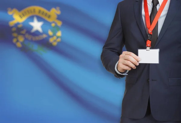 Бизнесмен Холдинг badge на тросе с государственным флагом США на фоне - Невада — стоковое фото