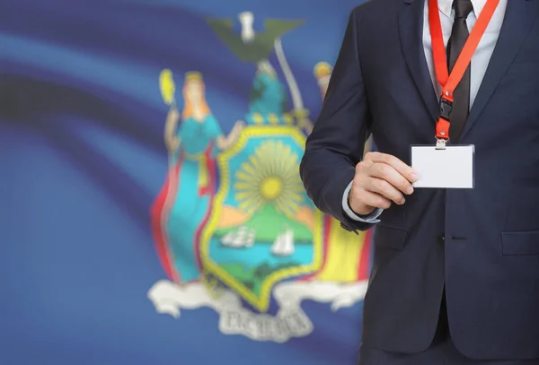 Επιχειρηματίας εκμετάλλευση σε ένα κορδόνι με σήμα ΗΠΑ κράτους σημαίας για φόντο - Νέα Υόρκη — Φωτογραφία Αρχείου