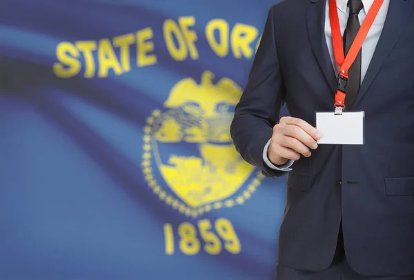Бізнесмен холдингу значок на ремінь з США державний прапор на фоні - штат Орегон — стокове фото