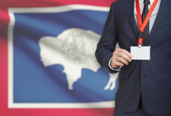 Geschäftsmann Holding Abzeichen auf ein Schlüsselband mit Usa Flagge auf Hintergrund - Wyoming — Stockfoto