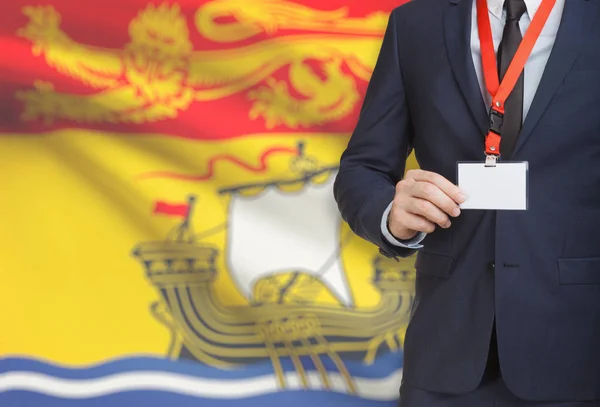 Geschäftsmann Holding Abzeichen auf ein Schlüsselband mit kanadischen Provinz Flagge auf Hintergrund - New Brunswick — Stockfoto