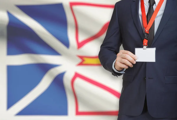 Distintivo de exploração do empresário em uma corda com a bandeira da província canadense em fundo - Newfoundland — Fotografia de Stock