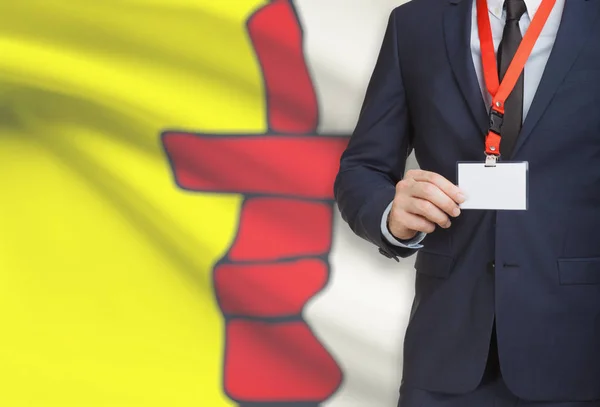 Geschäftsmann Holding Abzeichen auf ein Schlüsselband mit kanadischen Provinz Flagge auf Hintergrund - Nunavut — Stockfoto