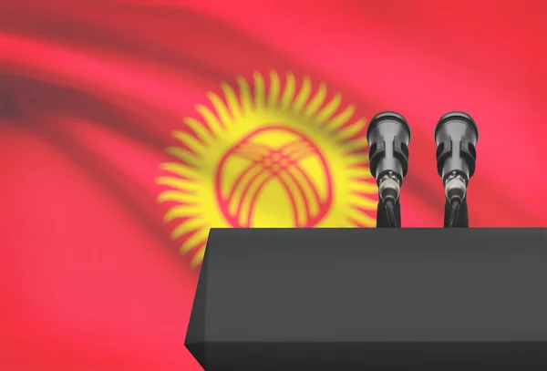 Άμβωνας και δύο μικρόφωνα με μια εθνική σημαία σε φόντο - Δημοκρατία της Κιργιζίας — Φωτογραφία Αρχείου