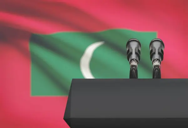 Púlpito y dos micrófonos con una bandera nacional de fondo - Maldivas — Foto de Stock