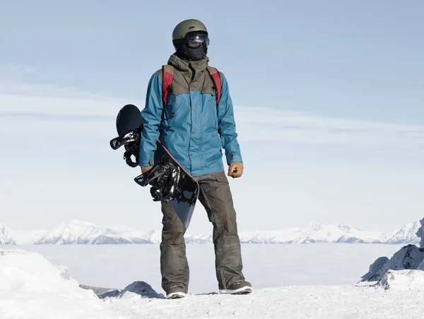 Snowboarder homme appréciant le paysage au sommet de la montagne. Image filtrée : Croix traitées effet vintage. — Photo