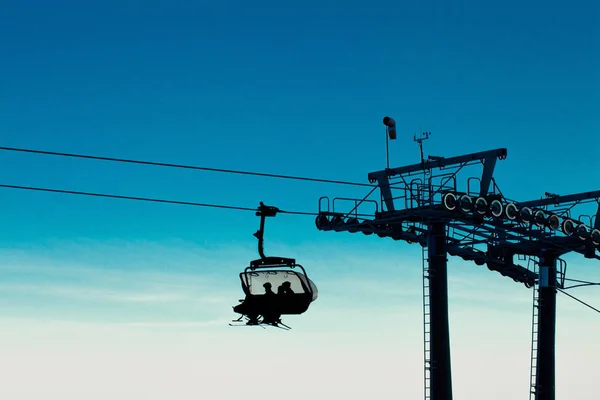 Teleférico de cadeira com esquiadores subindo — Fotografia de Stock