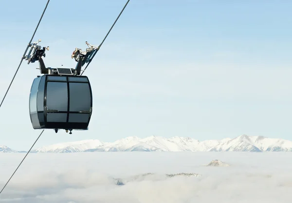 Kabine der Seilbahn hinauf über den Wolken an der Spitze eines Berges in einem Skigebiet — Stockfoto