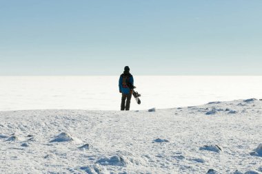 Bir dağın tepesinden manzara bir göz alarak snowboarder