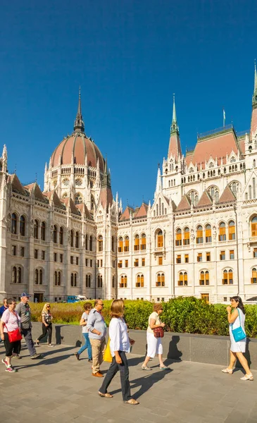 Budapest, Hungría - 16 de junio de 2016: Grupo de turistas pasando por el edificio de Parlamento húngaro en Budapest, Hungría - 16 de junio de 2016 —  Fotos de Stock