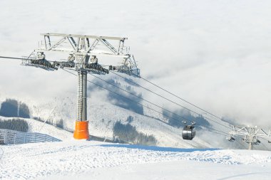 Yeni teleferik güneşli bir günde bir kış sporları tesisi alanı, Dağları yukarı ve aşağı gidiyor