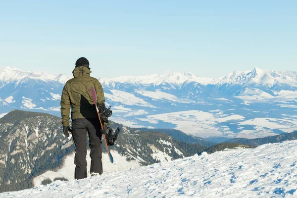 Сноубордист дивиться на красиві пейзажі з вершини гори — стокове фото