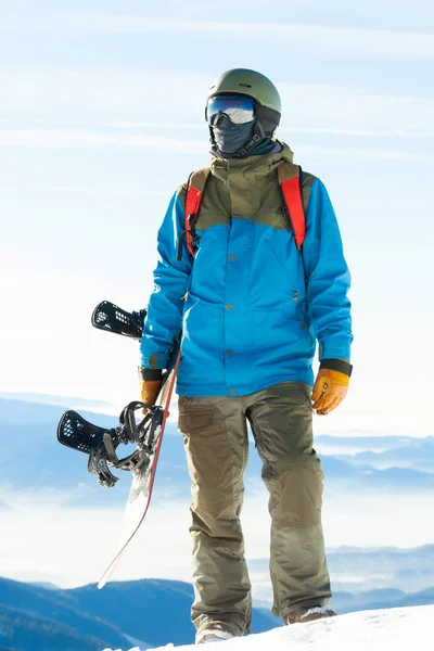 Foto de joven snowboarder en la situación del casco en la parte superior de una montaña de cerca —  Fotos de Stock