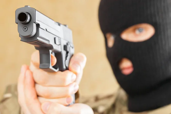 Άνθρωπος στη μαύρη μάσκα κρατώντας όπλο μπροστά του — Φωτογραφία Αρχείου