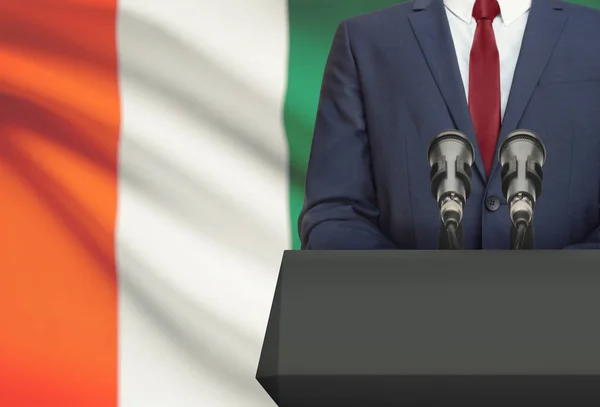 Businessman or politician making speech from behind a pulpit with national flag on background - Ivory Coast — Stock Photo, Image