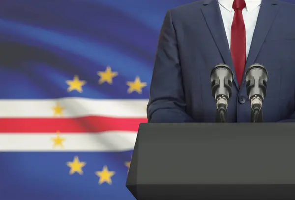 Businessman or politician making speech from behind a pulpit with national flag on background - Cape Verde - Cabo Verde — Foto de Stock