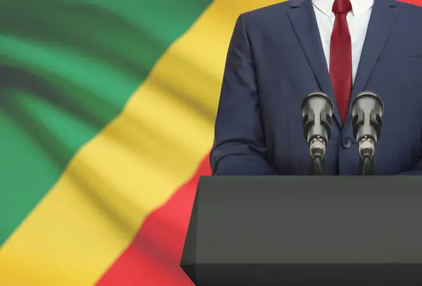 Biznesmen i polityk, Dokonywanie mowy zza ambony z flagi narodowej na tle - Kongo — Zdjęcie stockowe