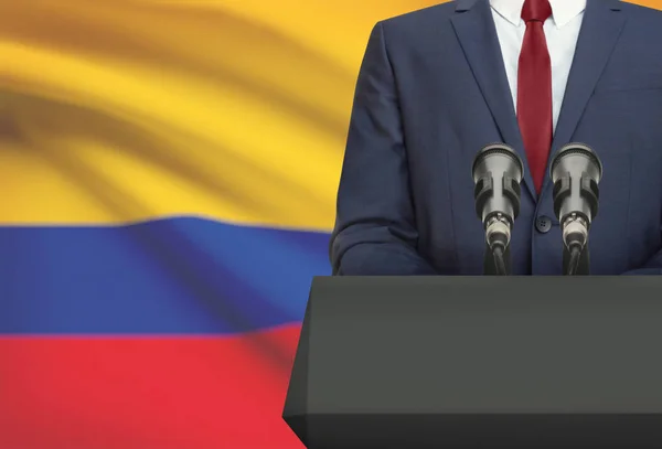 Businessman or politician making speech from behind a pulpit with national flag on background - Colombia — Foto de Stock