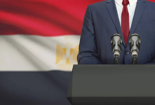 Бизнесмен и политик, делая речи сзади амвон с национальным флагом на фоне - Египет — стоковое фото
