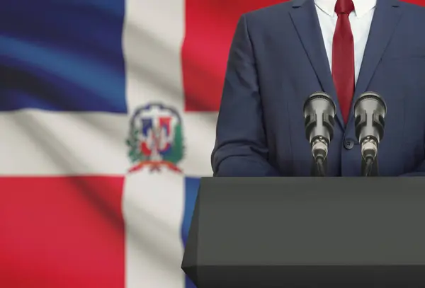 Zakenman of politicus maken van toespraak achter een preekstoel met nationale vlag op de achtergrond - Dominicaanse Republiek — Stockfoto