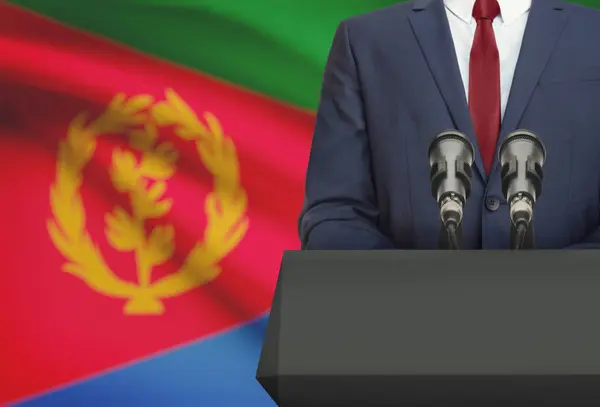Businessman or politician making speech from behind a pulpit with national flag on background - Eritrea — Stock Photo, Image