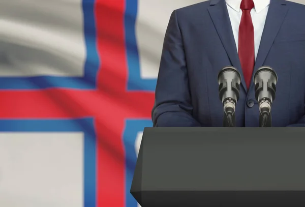Biznesmen i polityk, Dokonywanie mowy zza ambony z flagi narodowej na tle - Wyspy Owcze — Zdjęcie stockowe