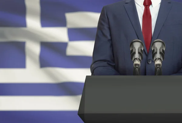 Homme d’affaires ou un politicien faire discours derrière un pupitre avec drapeau national sur fond - Grèce — Photo