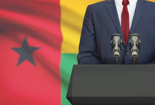 Biznesmen i polityk, Dokonywanie mowy zza ambony z flagi narodowej na tle - Gwinea Bissau — Zdjęcie stockowe