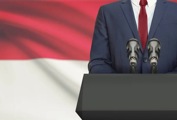 Businessman or politician making speech from behind a pulpit with national flag on background - Indonesia — Stock Photo, Image