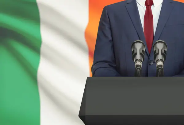 Businessman or politician making speech from behind a pulpit with national flag on background - Ireland — Stock Photo, Image