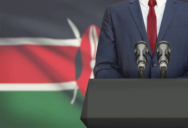 Businessman or politician making speech from behind a pulpit with national flag on background - Kenya