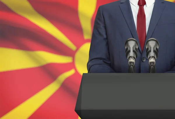 Geschäftsmann oder Politiker Redebeitrag von hinten eine Kanzel mit Nationalflagge auf Hintergrund - Mazedonien — Stockfoto