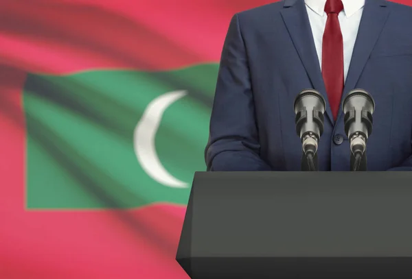 Businessman or politician making speech from behind a pulpit with national flag on background - Maldives — Foto de Stock