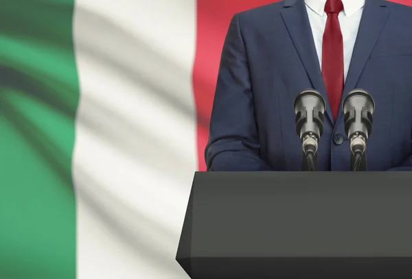 Uomo d'affari o politico fa discorso da dietro un pulpito con la bandiera nazionale sulla priorità bassa - Italia Foto Stock Royalty Free