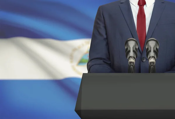 Homme d’affaires ou un politicien faire discours derrière un pupitre avec drapeau national sur fond - Nicaragua — Photo