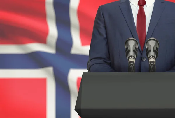 Uomo d'affari o politico fa discorso da dietro un pulpito con la bandiera nazionale sulla priorità bassa - Norvegia — Foto Stock