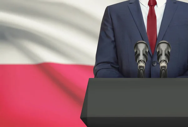 Uomo d'affari o politico fa discorso da dietro un pulpito con la bandiera nazionale sulla priorità bassa - Polonia — Foto Stock