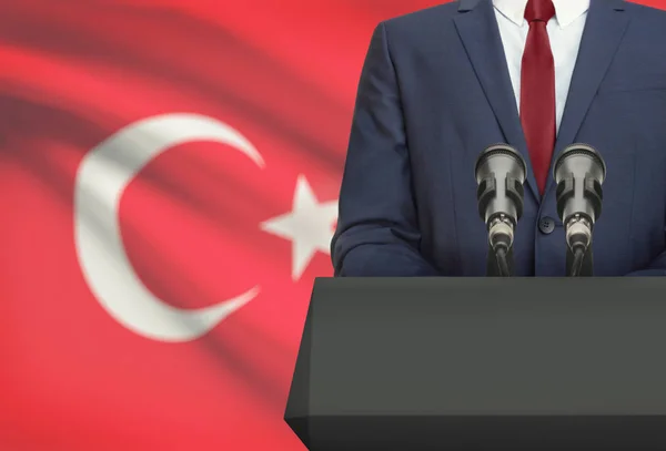 Businessman or politician making speech from behind a pulpit with national flag on background - Turkey — Stock Photo, Image