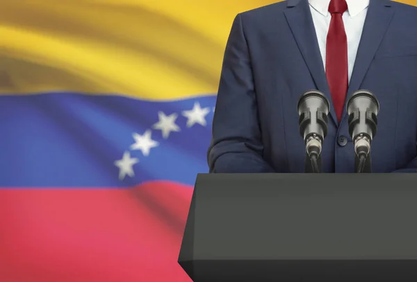 Businessman or politician making speech from behind a pulpit with national flag on background - Venezuela — Foto de Stock