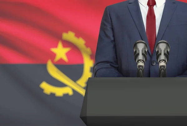 Businessman or politician making speech from behind a pulpit with national flag on background - Angola — Fotografia de Stock