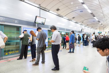 Seoul, Güney Kore - 28 Şubat 2017: bir metro platformda doğrultusunda ayakta ve 28 Şubat 2017 - Seoul, Güney Kore - gelmek onların tren bekleyen insanlar