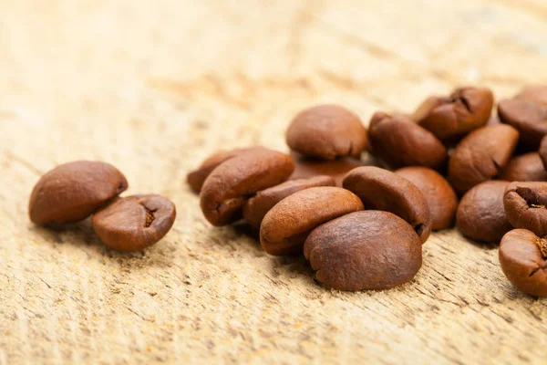 Roasted coffee beans on rustic wooden table — Stock Photo, Image